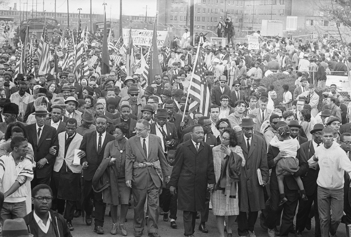 In occasione della marcia partita da Selma il 25 marzo 1965, Martin Luther King, arrivato alle porte del palazzo del governatore dell’Alabama, pronunciò uno dei suoi discorsi più toccanti: How long? Not long